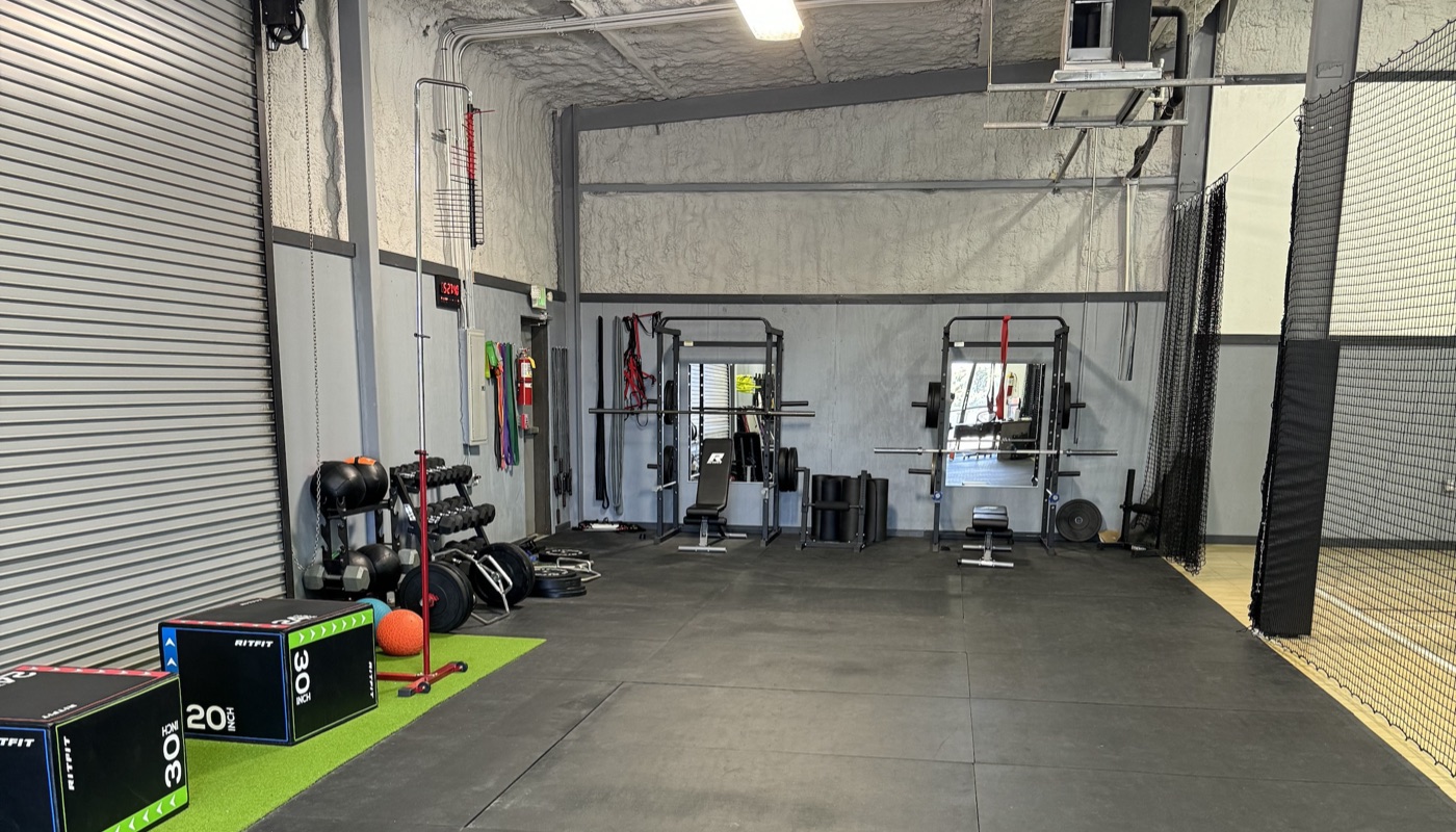 Liberty Hill Athletics private weight room with squat racks, benches, and free weights